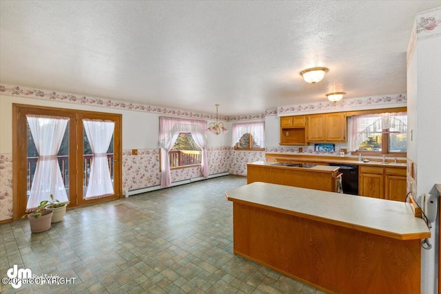 kitchen with kitchen peninsula, baseboard heating, an inviting chandelier, dishwasher, and hanging light fixtures