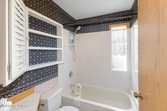 bathroom featuring tiled shower / bath and toilet