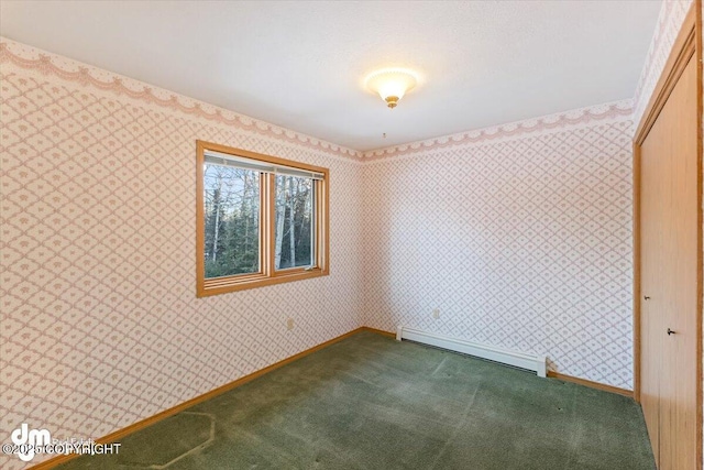 spare room with dark carpet and a baseboard radiator