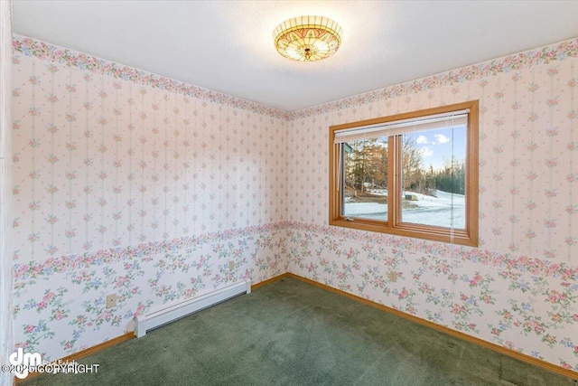 carpeted spare room featuring a baseboard heating unit