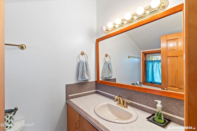 bathroom featuring vanity and lofted ceiling