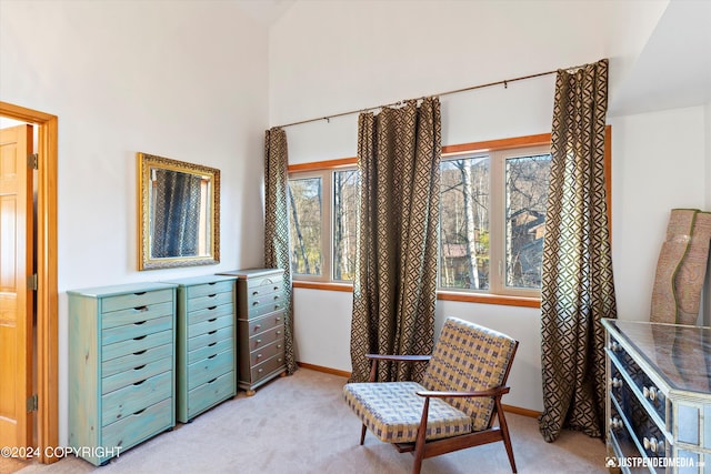 sitting room featuring light colored carpet and lofted ceiling