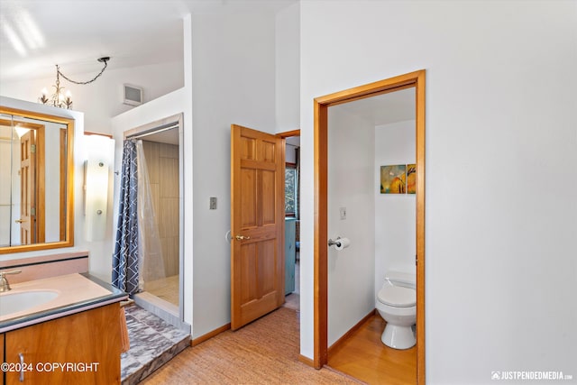 bathroom with a shower with shower curtain, vaulted ceiling, toilet, and an inviting chandelier