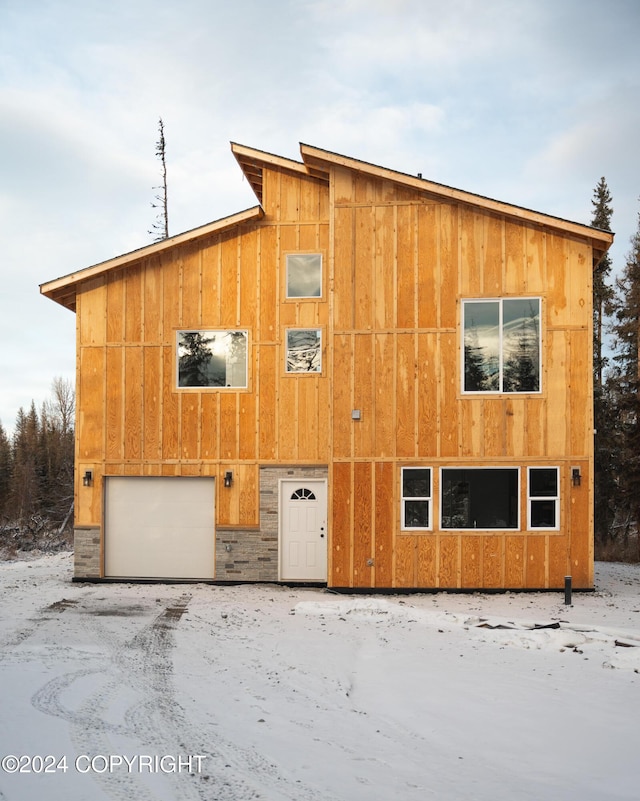 snow covered property featuring a garage