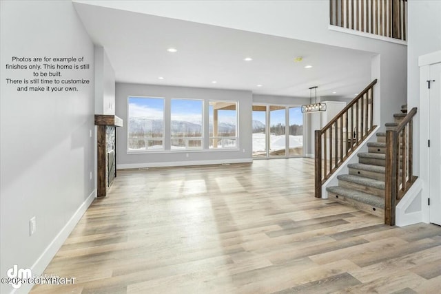 unfurnished living room with a chandelier and light hardwood / wood-style flooring