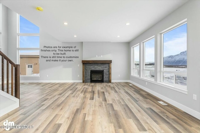 unfurnished living room with a mountain view, light hardwood / wood-style flooring, and a fireplace