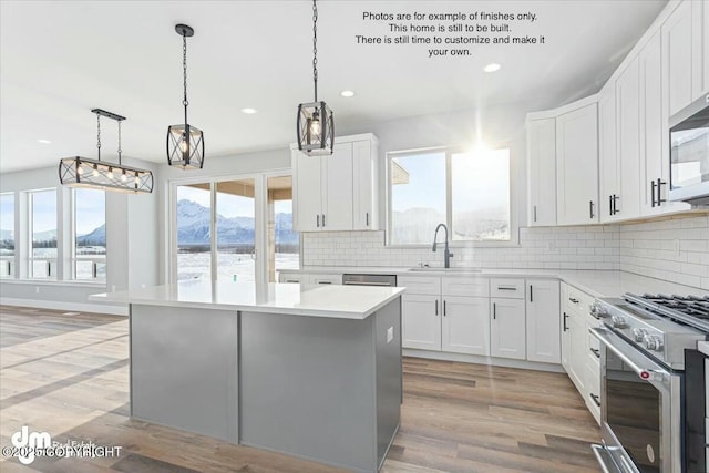 kitchen featuring white cabinetry, a mountain view, a center island, and appliances with stainless steel finishes