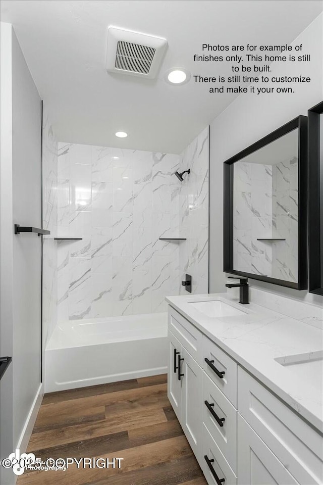 bathroom featuring vanity, hardwood / wood-style floors, and tiled shower / bath combo