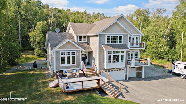 back of property with a lawn, outdoor lounge area, a deck, a balcony, and a garage