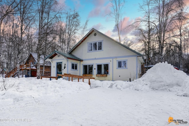 snow covered property featuring a standing seam roof and metal roof