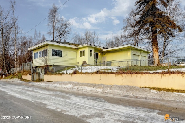 view of front of house with a fenced front yard and an attached garage