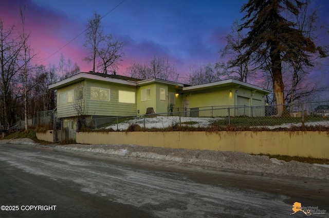 view of front of house featuring a fenced front yard, a garage, and driveway