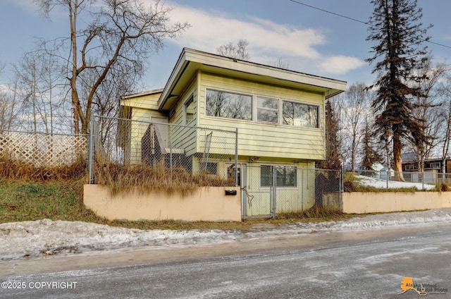 view of front of house with a fenced front yard and a gate