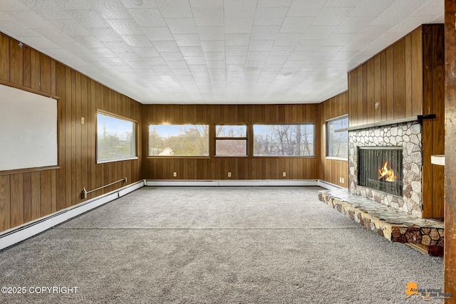 unfurnished living room featuring wood walls, a fireplace, and carpet floors