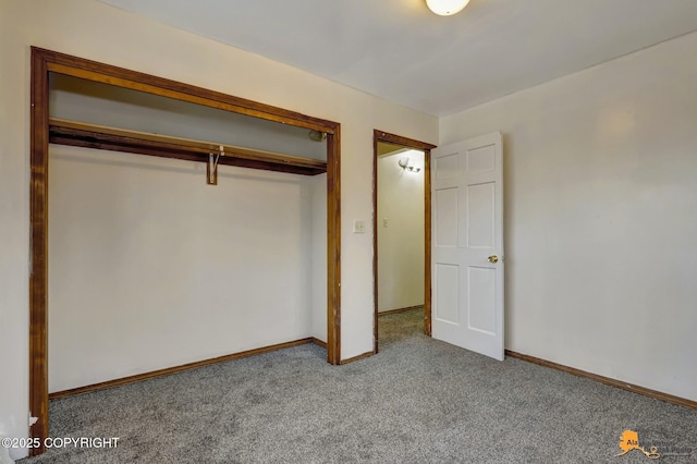 unfurnished bedroom featuring carpet, baseboards, and a closet