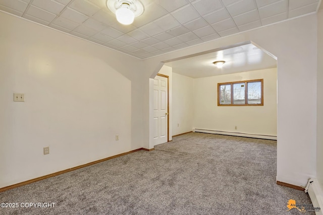 spare room with arched walkways, a baseboard heating unit, baseboards, and carpet floors