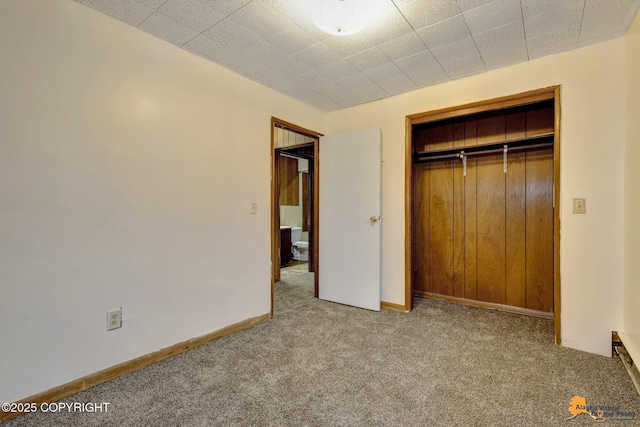 unfurnished bedroom featuring a closet, carpet floors, and baseboards