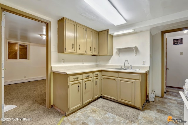 kitchen with light countertops, light colored carpet, baseboard heating, and a sink