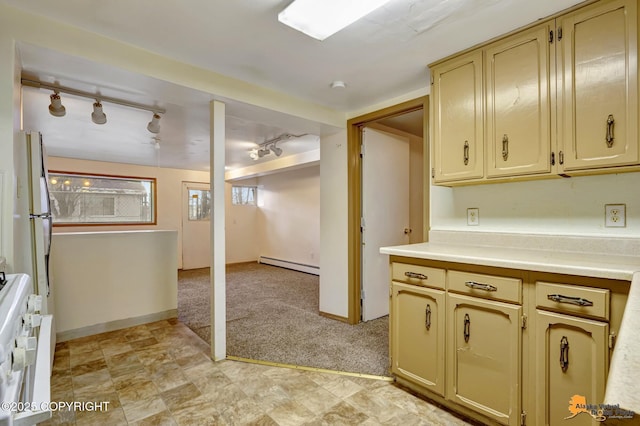 kitchen featuring a baseboard radiator, light countertops, cream cabinetry, light carpet, and range