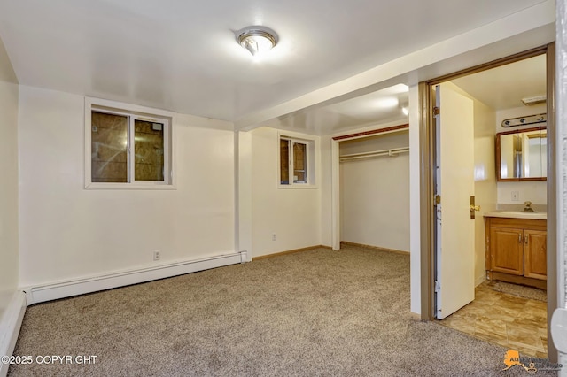 unfurnished bedroom featuring light carpet, baseboards, a closet, and a baseboard radiator