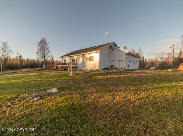 view of side of property with a wooden deck and a yard