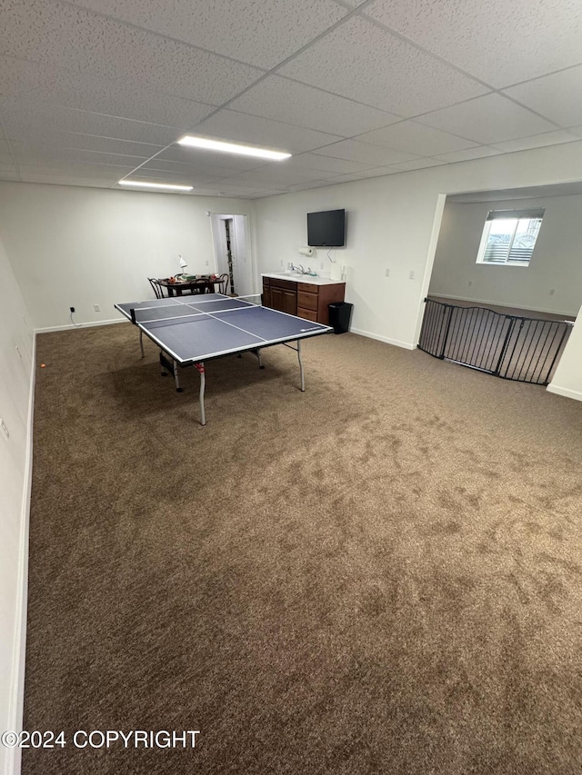 rec room featuring carpet and a paneled ceiling