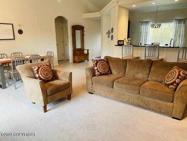 living room with a notable chandelier and light carpet