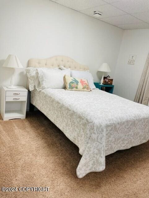 bedroom with carpet flooring and a paneled ceiling