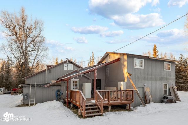 snow covered property with a deck