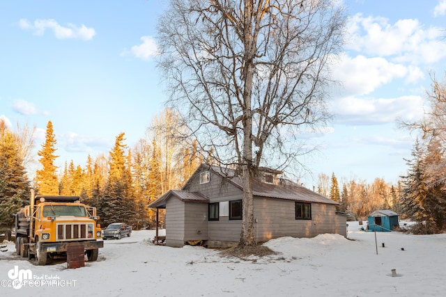 snow covered property with an outdoor structure