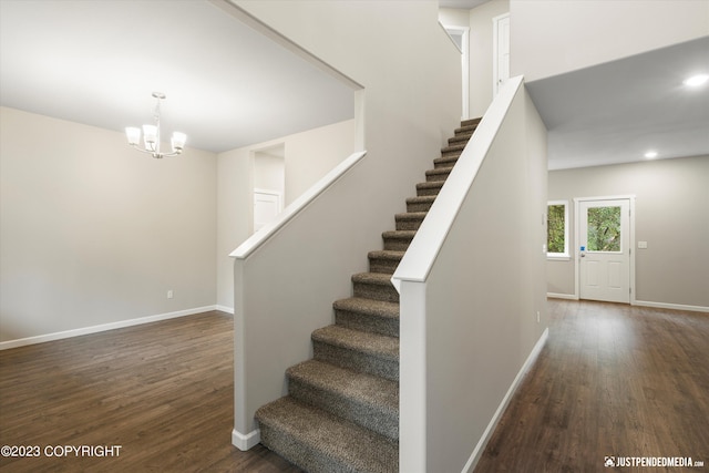 stairway with wood finished floors, a chandelier, baseboards, and recessed lighting