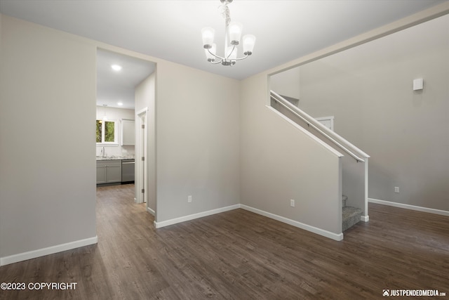 empty room featuring a chandelier, stairs, dark wood-style flooring, baseboards, and recessed lighting