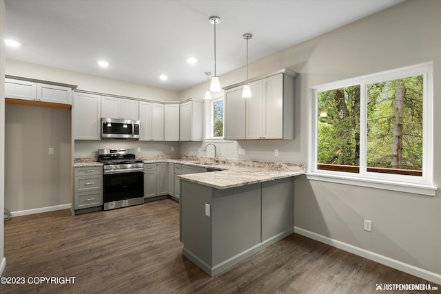 kitchen featuring stainless steel appliances, a peninsula, plenty of natural light, baseboards, and recessed lighting