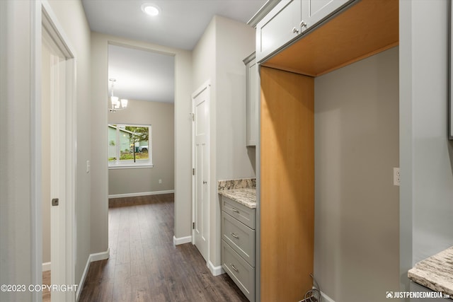 corridor with dark wood-style floors, a chandelier, baseboards, and recessed lighting