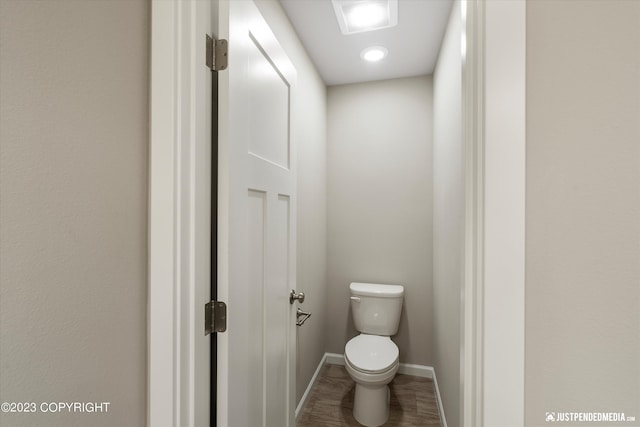 bathroom featuring toilet, baseboards, and wood finished floors