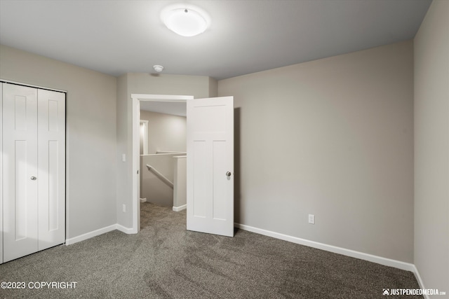 unfurnished bedroom featuring carpet, baseboards, and a closet