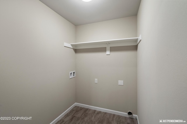 laundry area with washer hookup, wood finished floors, and baseboards