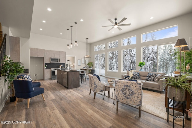 living room featuring sink, hardwood / wood-style flooring, plenty of natural light, and ceiling fan