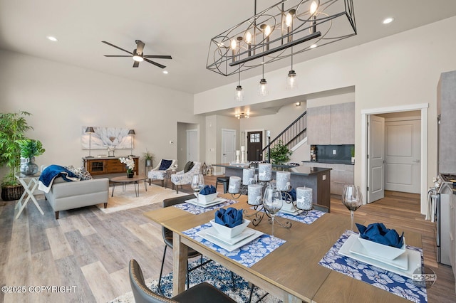 dining space with ceiling fan and light wood-type flooring