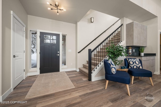 foyer with dark hardwood / wood-style flooring and a chandelier