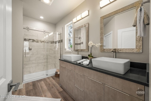 bathroom featuring hardwood / wood-style floors, vanity, and a shower with door