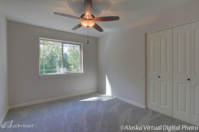 unfurnished bedroom with carpet flooring, ceiling fan, and a closet