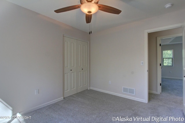 unfurnished bedroom with a closet, light colored carpet, and ceiling fan