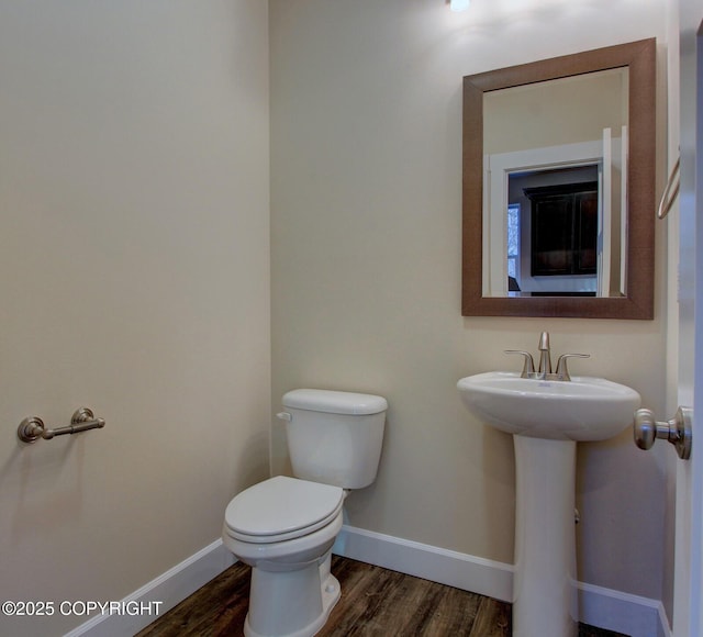 bathroom with hardwood / wood-style floors, toilet, and sink