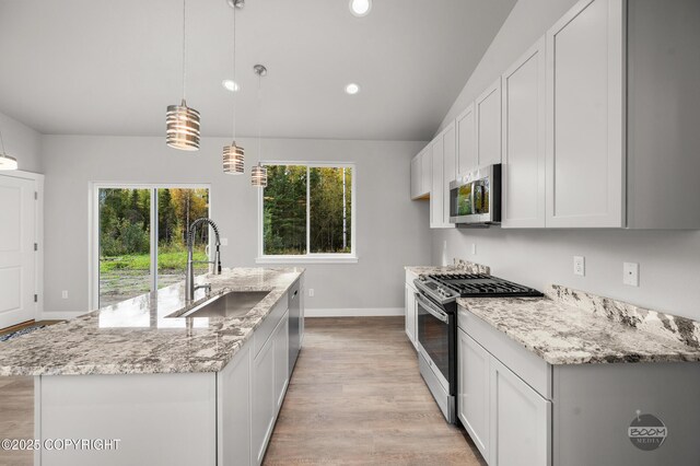 L12 Jasmine Rd, Chugiak, AK 99567 - kitchen with appliances with stainless steel finishes, a sink, light wood-style floors, baseboards, and recessed lighting