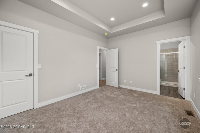 L12 Jasmine Rd, Chugiak, AK 99567 - unfurnished bedroom featuring carpet flooring, baseboards, recessed lighting, ensuite bath, and a tray ceiling