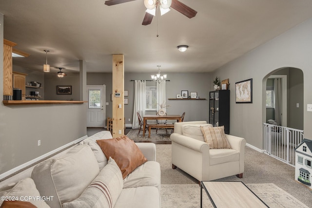 living room featuring light colored carpet and ceiling fan with notable chandelier