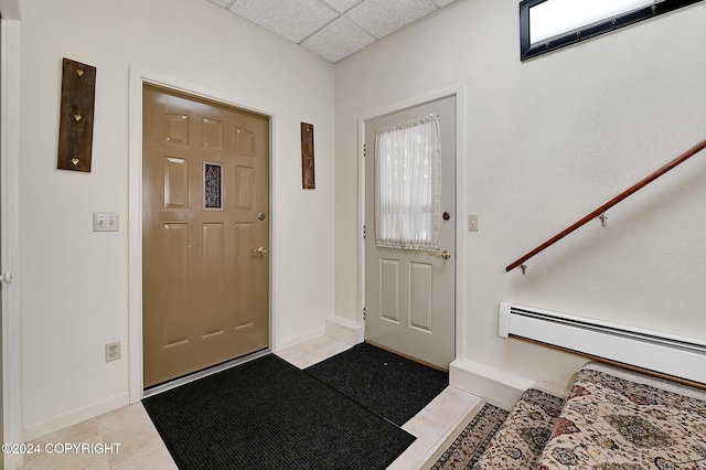 tiled foyer entrance featuring a paneled ceiling and baseboard heating