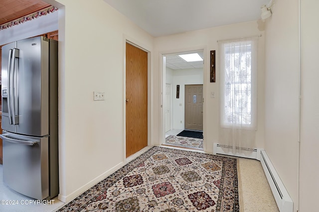 interior space featuring a drop ceiling and a baseboard heating unit