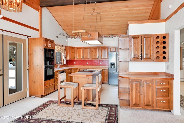 kitchen featuring a center island, rail lighting, a towering ceiling, a kitchen bar, and black appliances